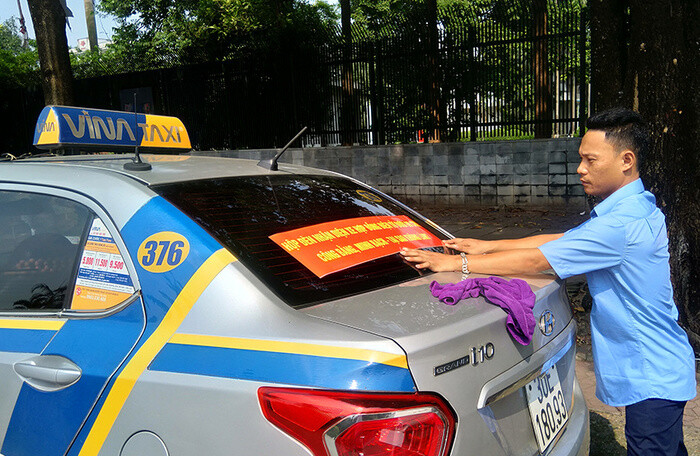 Tài xế taxi truyền thống dán băng rôn ủng hộ việc gắn mào trên xe taxi công nghệ
